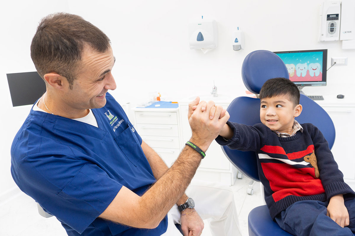 Dr Galeano gioca con bambino paziente dello studio Villa Chigi Odontoiatria